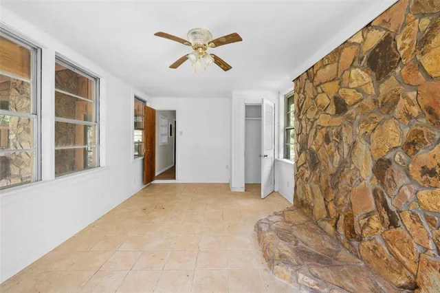 a view of a hallway with wooden floor and a bathroom