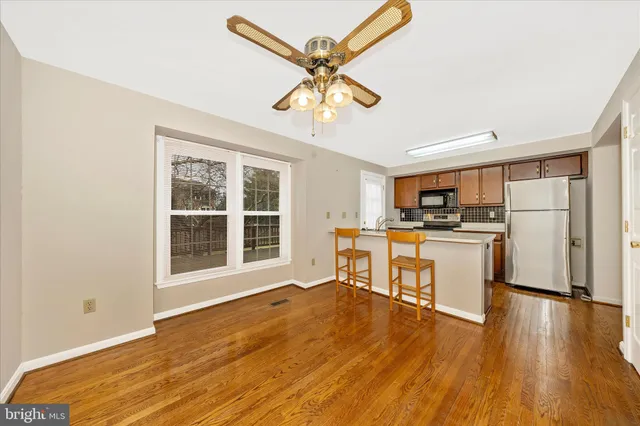 a view of kitchen with furniture appliances wooden floor and window