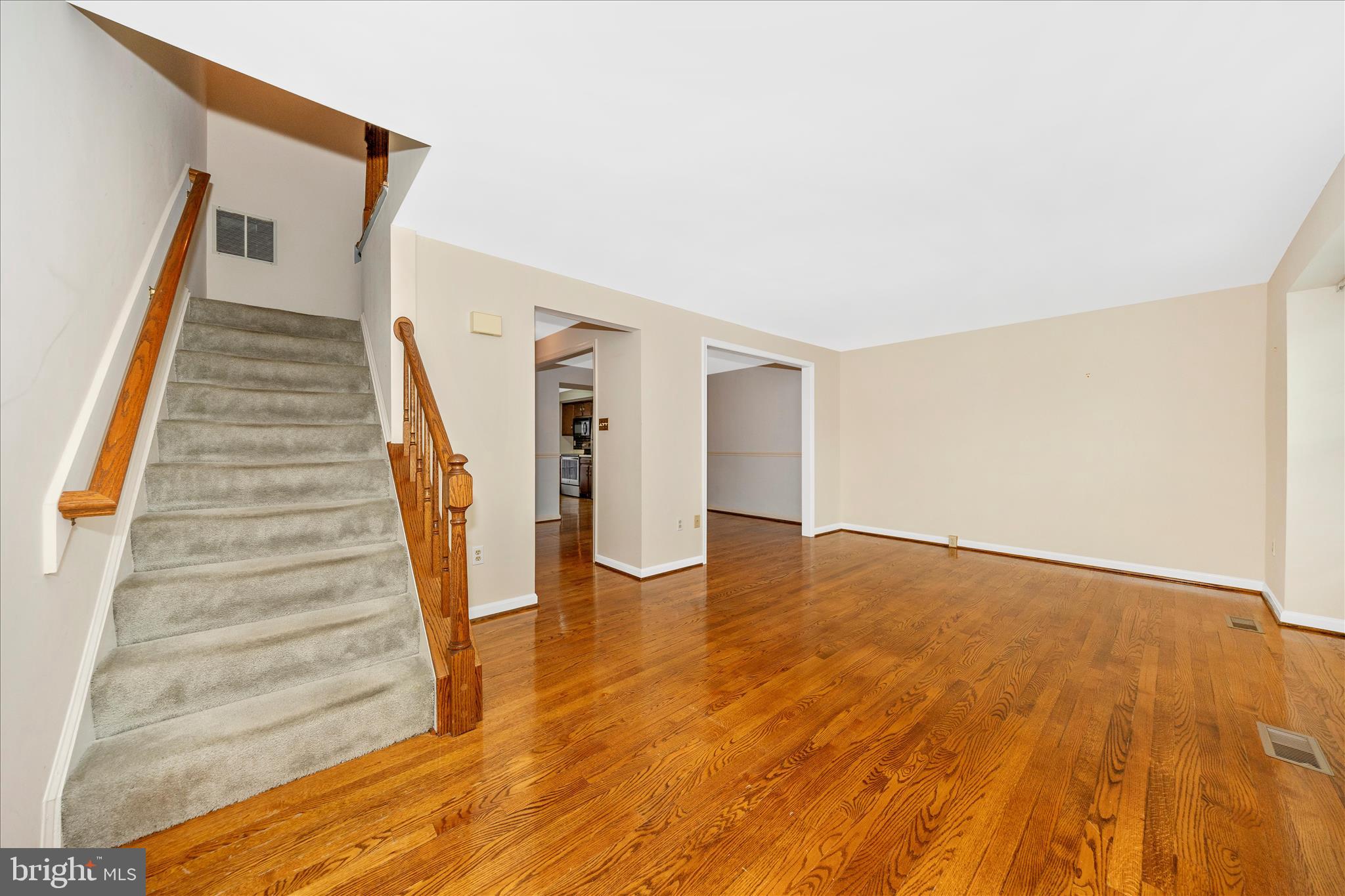 8007 Broken Reed Court Frederick, MD 21701 - Photo 7 of 72 a view of an empty room with wooden floor and stairs