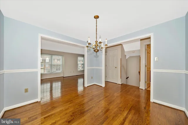 a view of a livingroom with wooden floor and a ceiling fan