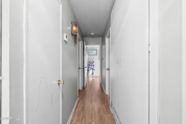 a view of a hallway with wooden floor and closet
