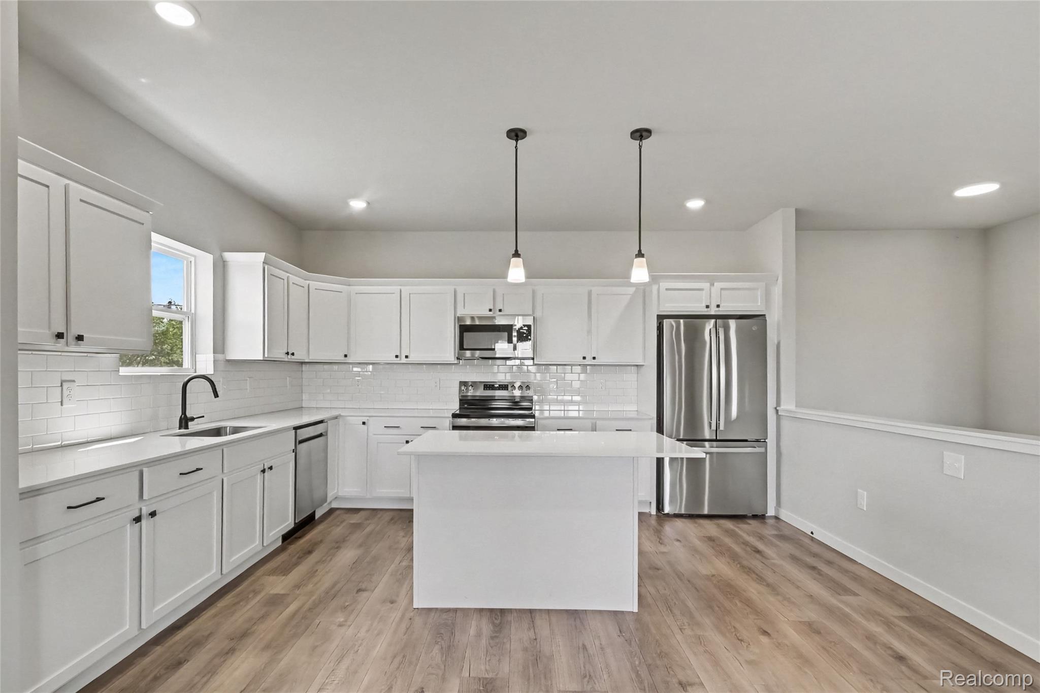 5528 Lahring Road Linden, MI 48451 - Photo 3 of 39 The kitchen includes Quartz counters with subway tile backsplash, large center island with extended edge counter and pendant lighting above. Stainless steel appliances are included!