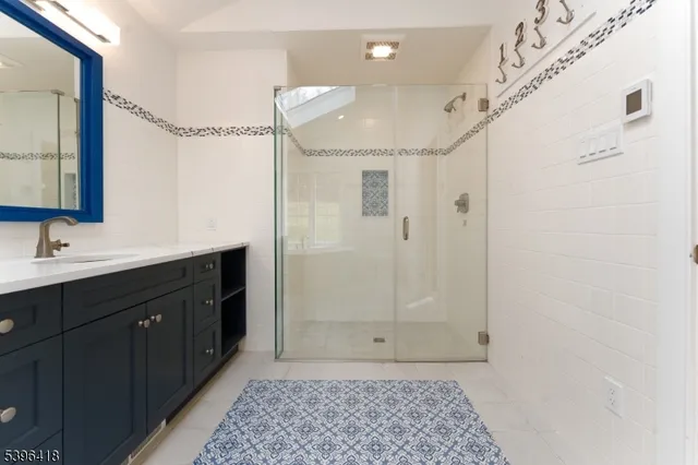 a bathroom with a sink a shower a mirror and a bathtub