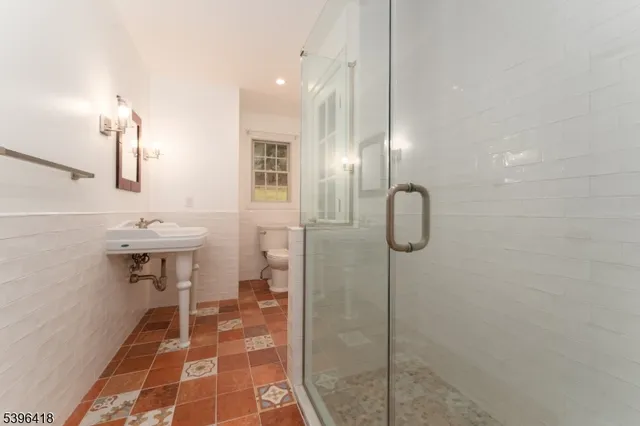 a bathroom with a sink shower and a mirror