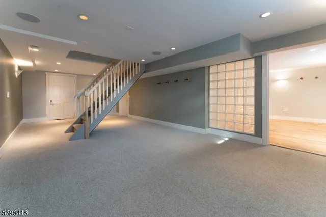 a view of an empty room with stairs and a window