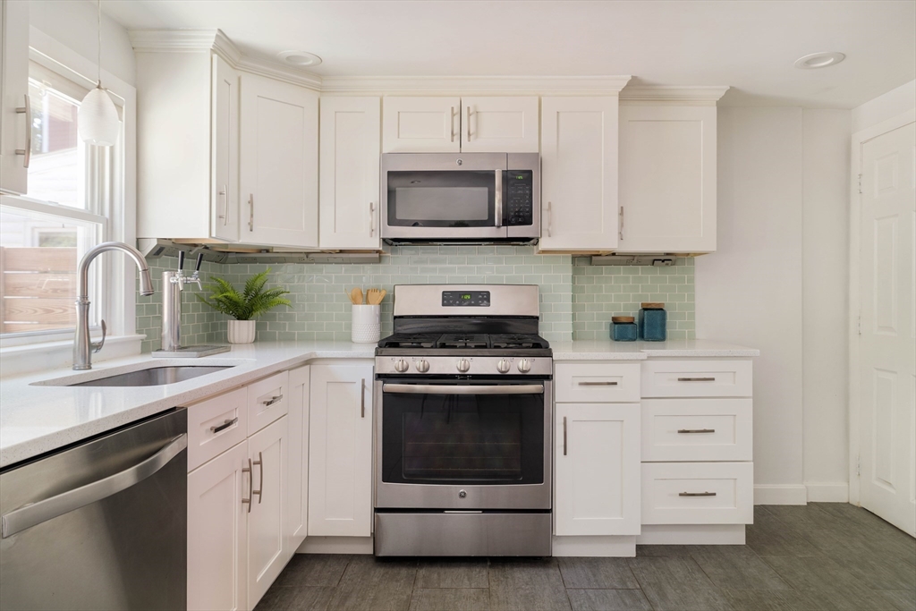 24 Goldsmith Street Boston, MA 02130 - Photo 5 of 23 a kitchen with white cabinets and white appliances