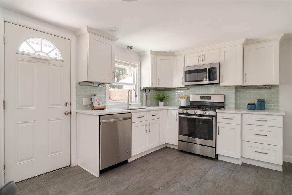 24 Goldsmith Street Boston, MA 02130 - Photo 6 of 23 a kitchen with granite countertop white cabinets and stainless steel appliances