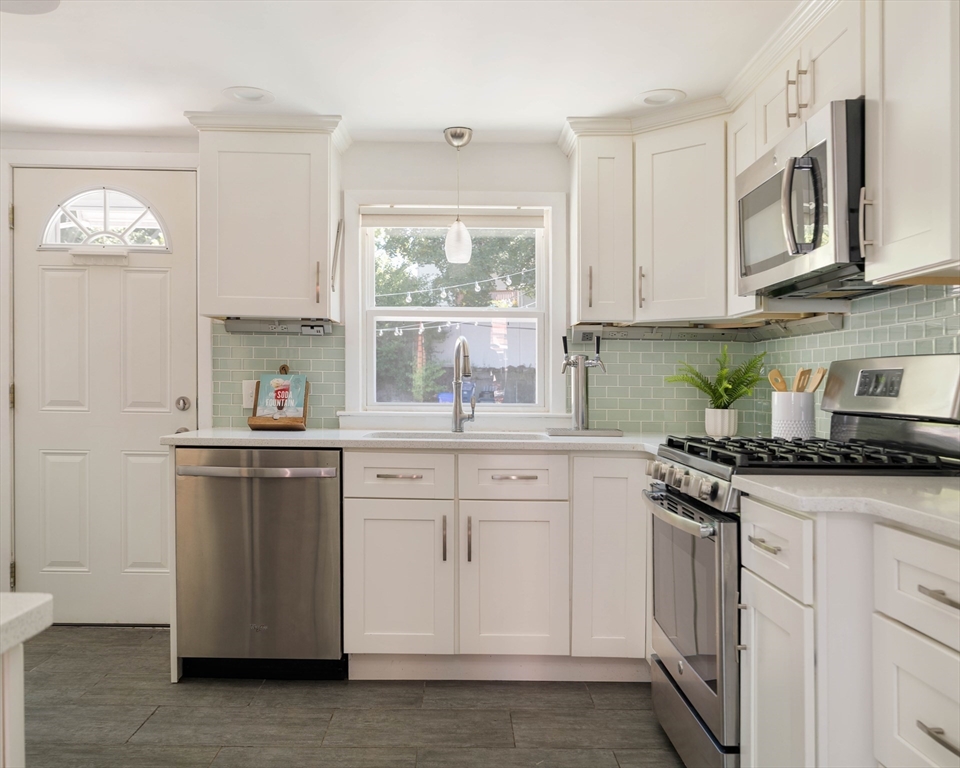 24 Goldsmith Street Boston, MA 02130 - Photo 7 of 23 a kitchen with stainless steel appliances granite countertop white cabinets a sink and dishwasher