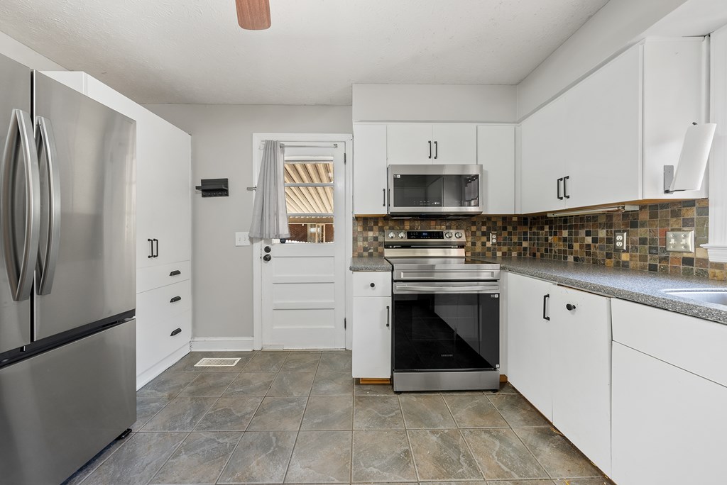 831 53rd Street Columbus, GA 31904 - Photo 7 of 37 a kitchen with white cabinets and stainless steel appliances