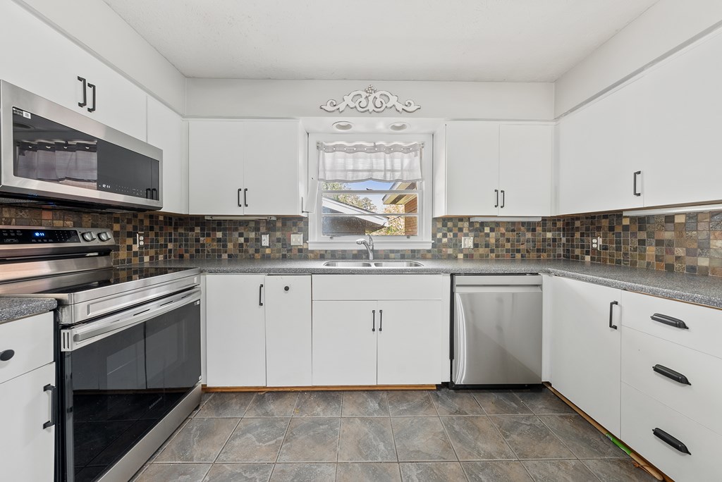 831 53rd Street Columbus, GA 31904 - Photo 8 of 37 a kitchen with granite countertop white cabinets stainless steel appliances a sink and a window