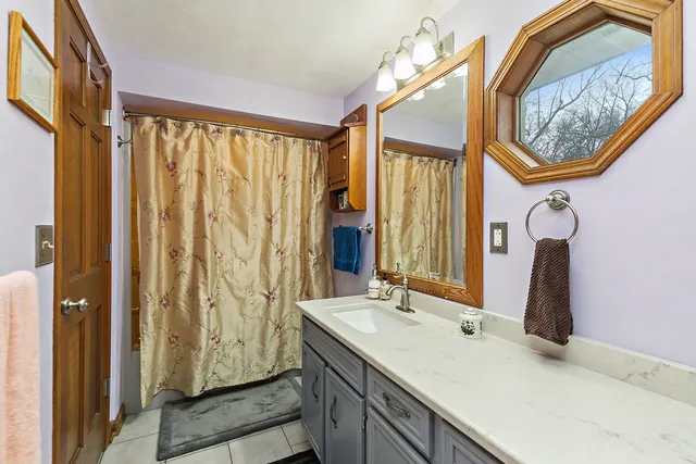 a bathroom with a granite countertop sink and a mirror