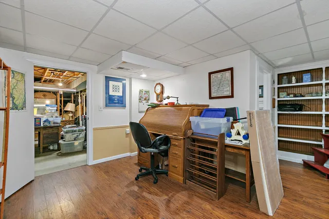 a view of a workspace with furniture and wooden floor