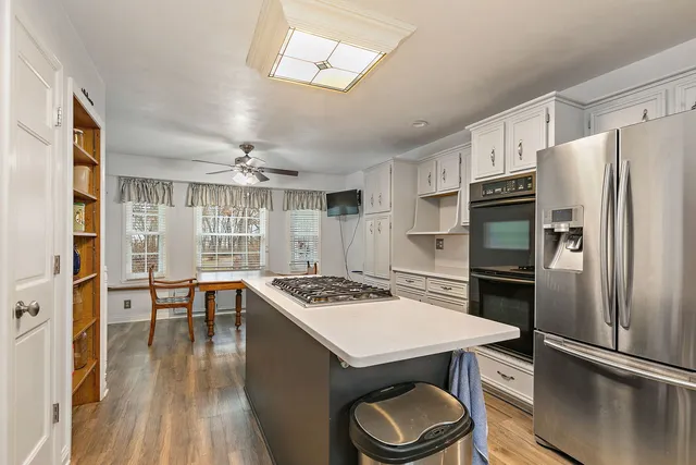 a kitchen with stainless steel appliances a stove a refrigerator and wooden cabinets