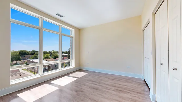 a view of an empty room with wooden floor