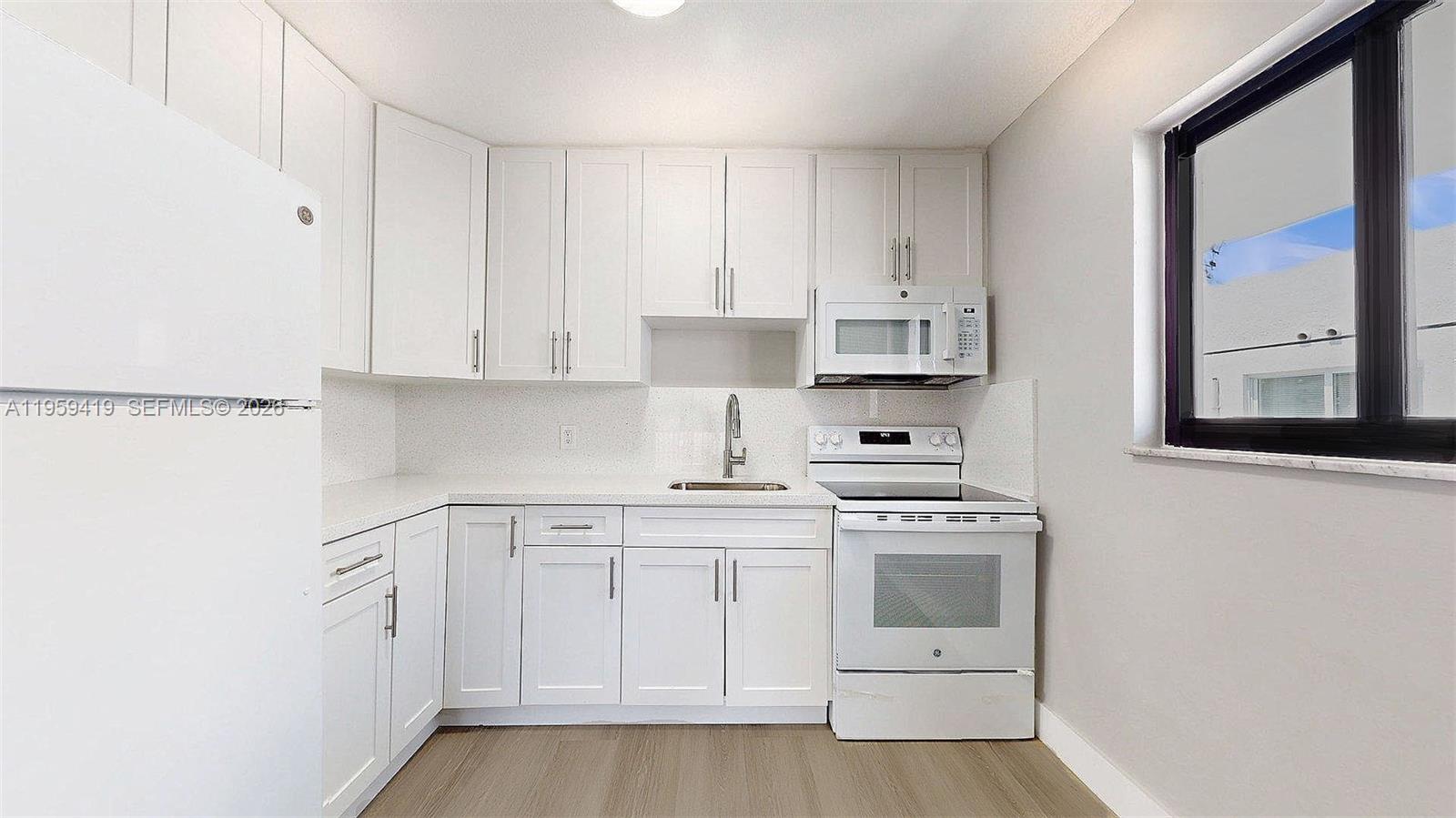 329 Southwest 9th Avenue Miami, FL 33130 - Photo 32 of 97 a kitchen with white cabinets and white appliances