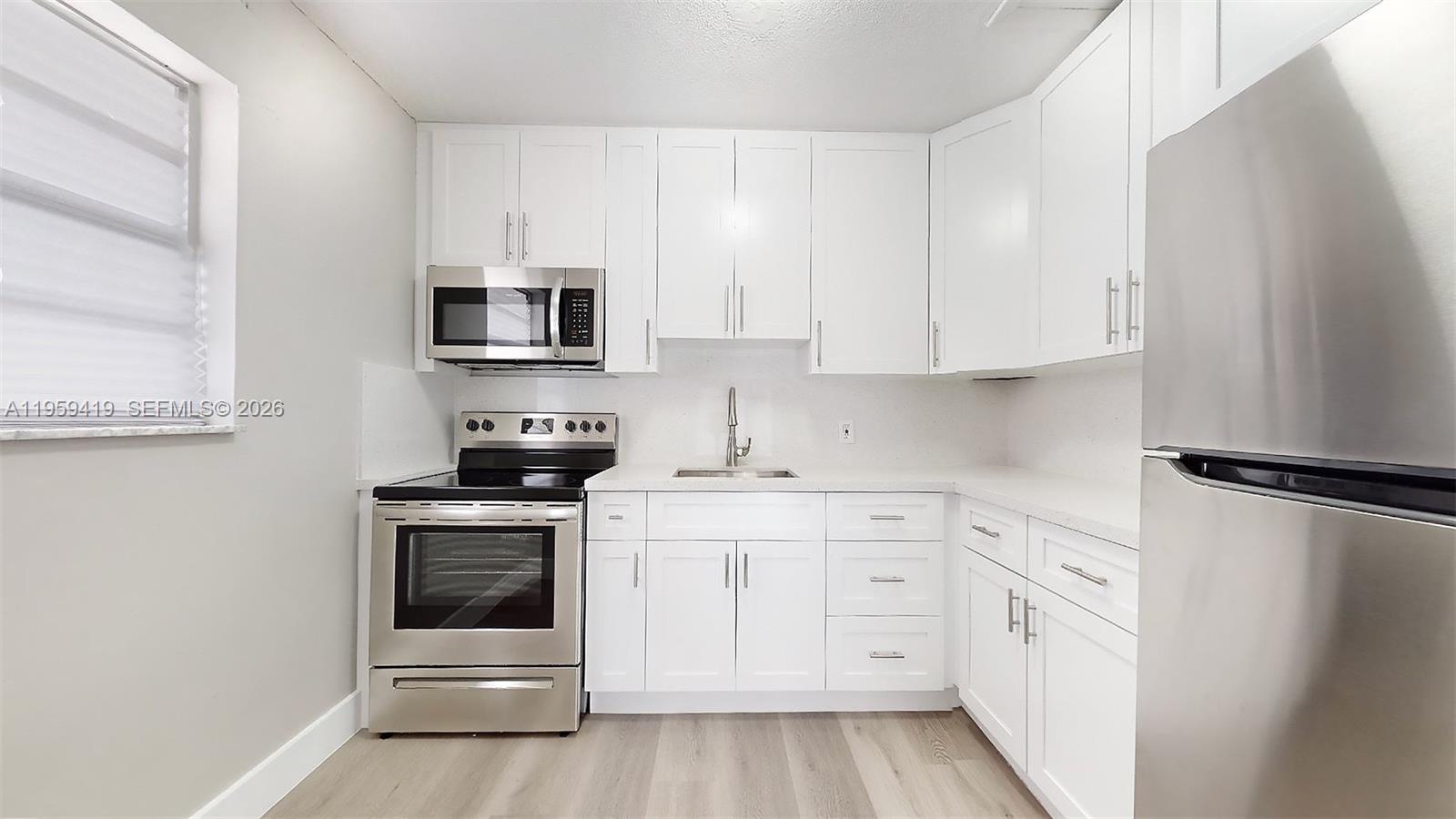 329 Southwest 9th Avenue Miami, FL 33130 - Photo 55 of 97 a kitchen with white cabinets and stainless steel appliances