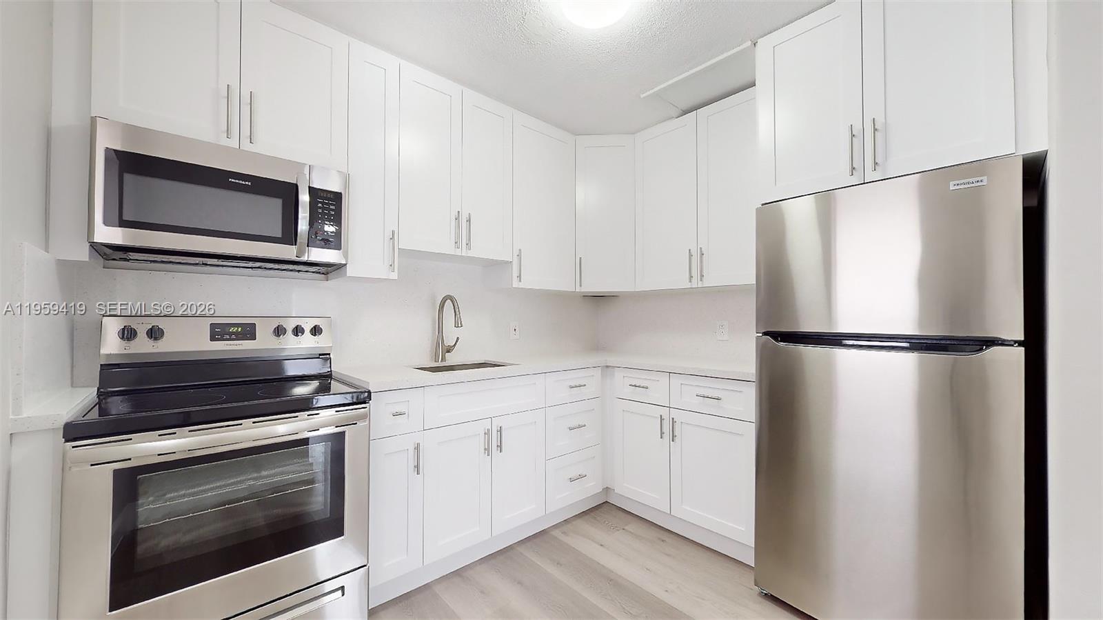 329 Southwest 9th Avenue Miami, FL 33130 - Photo 56 of 97 a kitchen with white cabinets and stainless steel appliances