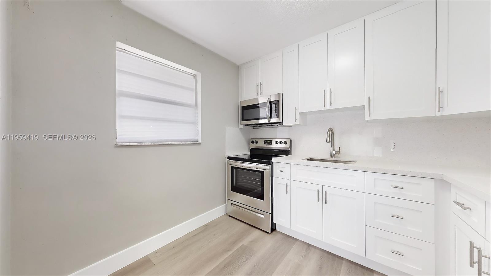 329 Southwest 9th Avenue Miami, FL 33130 - Photo 57 of 97 a kitchen with white cabinets stainless steel appliances and sink