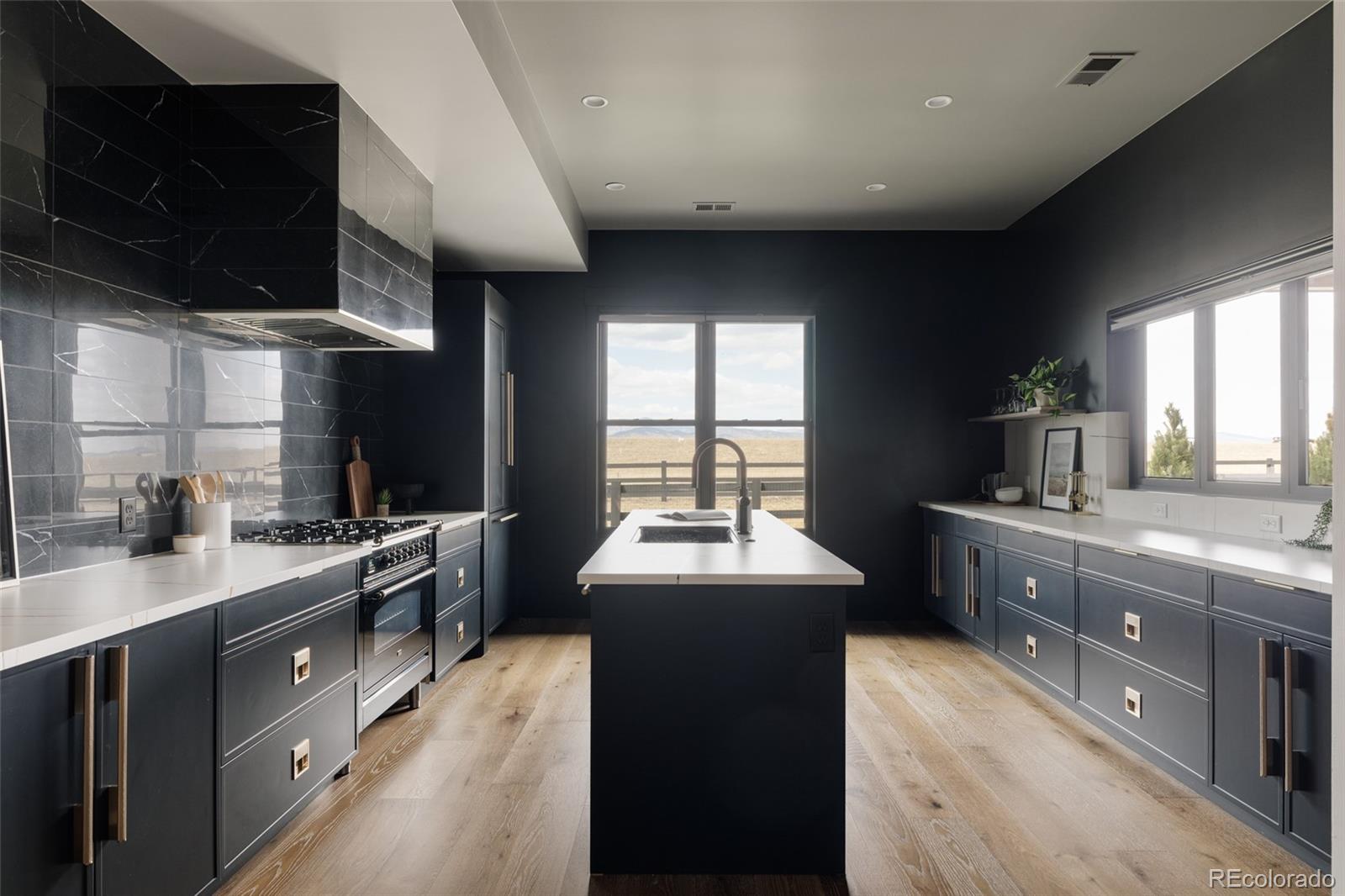 2531 Southwind Road Berthoud, CO 80513 - Photo 26 of 49 a kitchen with granite countertop a sink stainless steel appliances wooden floor and a counter top space
