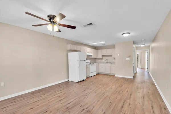 a view of a kitchen with wooden floor a sink and a window