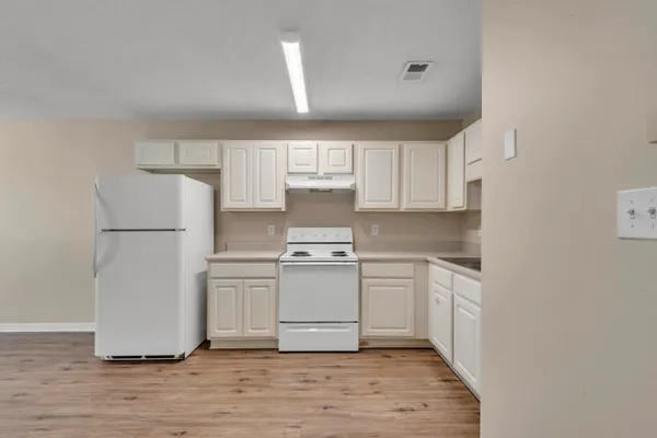 a kitchen with white cabinets and white appliances
