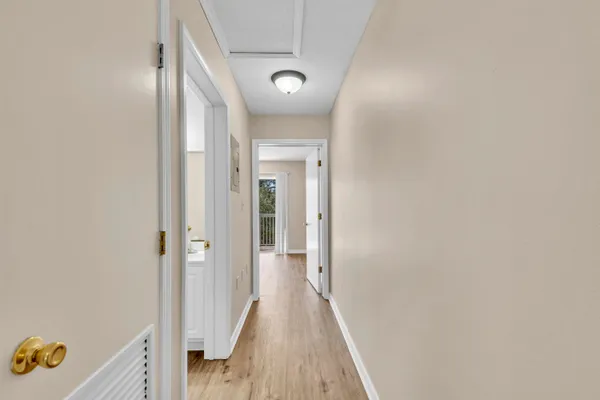 a view of a hallway with wooden floor and closet