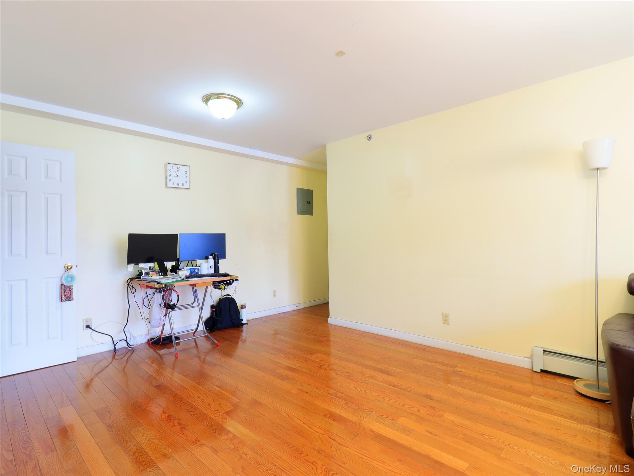 137-08 31st Road, Unit 5E Queens, NY 11354 - Photo 8 of 13 a room with furniture and a flat screen tv