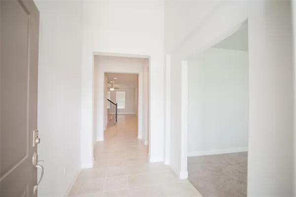 a view of a hallway with wooden floor and a bathroom