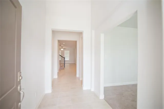 a view of a hallway with wooden floor and a bathroom