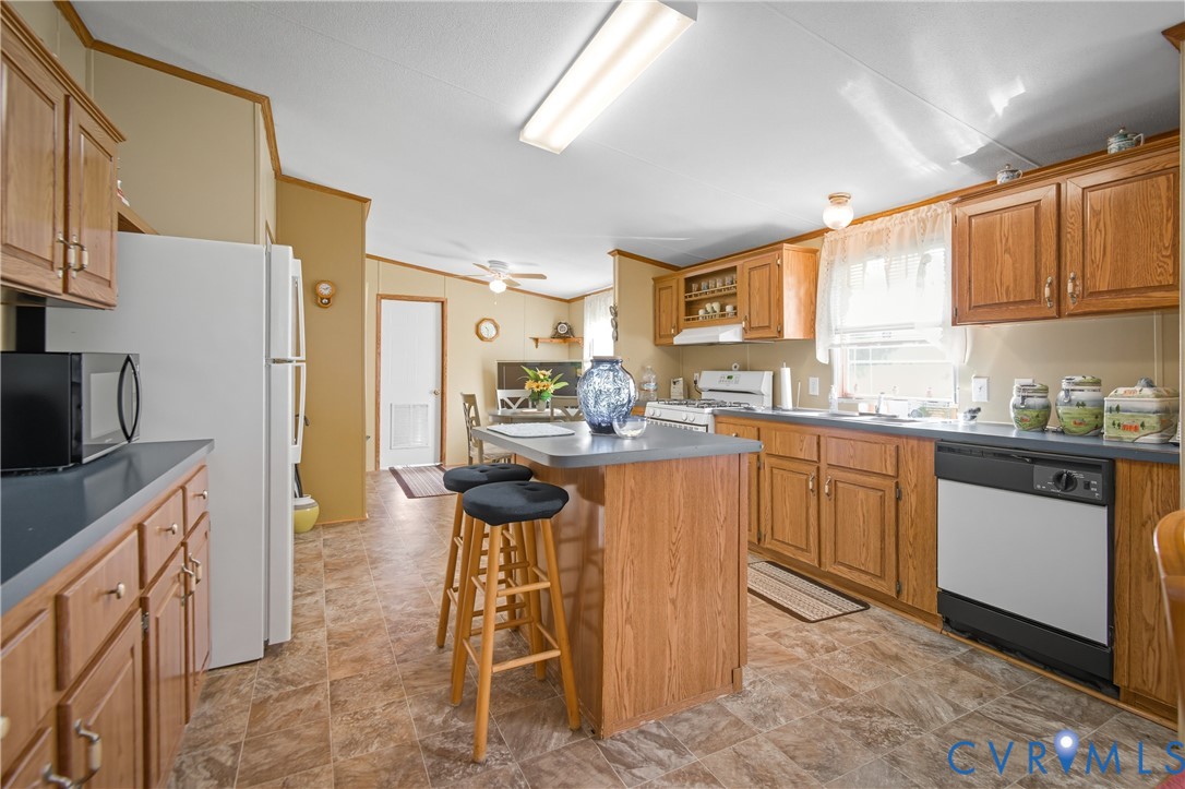 23344 Booth Road Stony Creek, VA 23882 - Photo 13 of 45 a kitchen with stainless steel appliances granite countertop a sink a stove a refrigerator cabinets and chairs