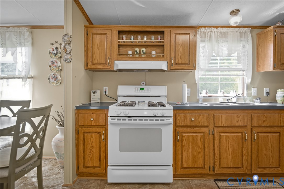 23344 Booth Road Stony Creek, VA 23882 - Photo 16 of 45 a kitchen with granite countertop a sink and a stove next to a window
