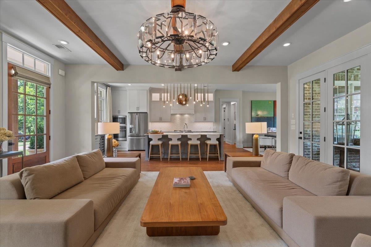 240 Burrows Road Collierville, TN 38017 - Photo 11 of 37 Open-concept living area with exposed wood beams and a contemporary chandelier