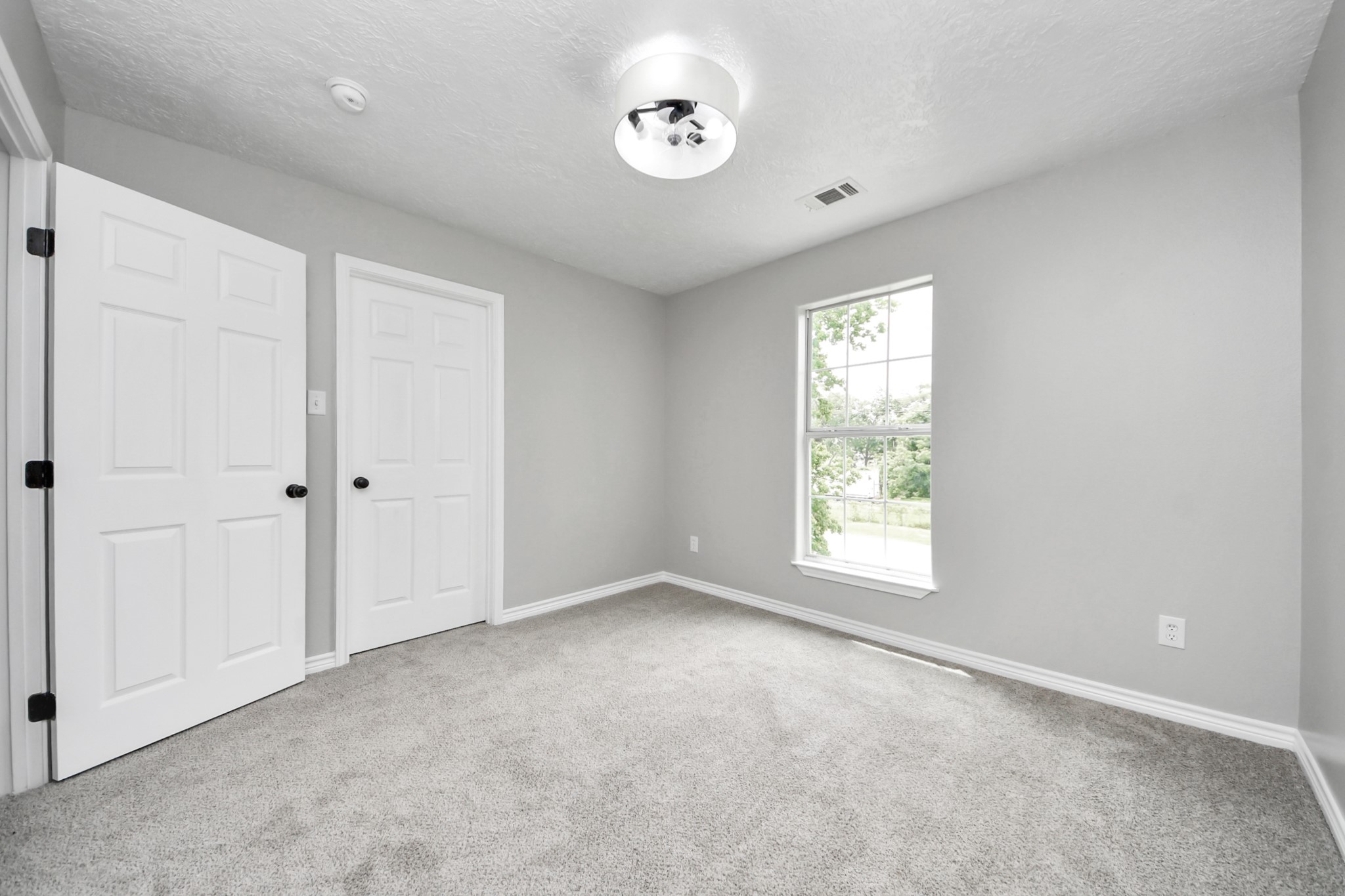 1105 East Kyle Road Clute, TX 77531 - Photo 35 of 44 The other secondary bedroom has neutral gray walls, a plush carpet, and a large window providing natural light. The ceiling has a modern light fixture, and the space offers a cozy, clean feel, ideal for a bedroom or office.