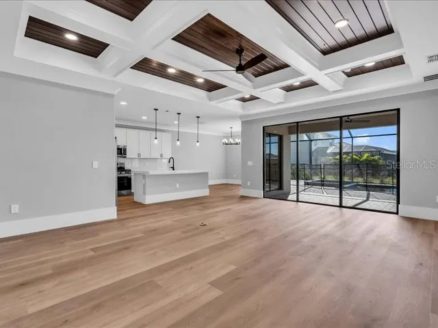 a view of an empty room with a window and chandelier