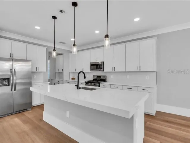 a kitchen with stainless steel appliances a refrigerator sink and microwave