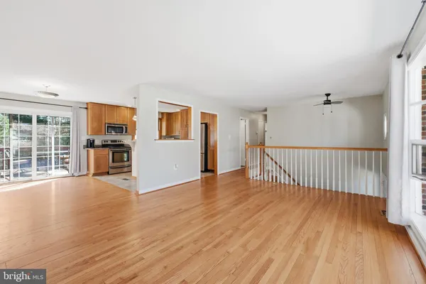 a view of a big room with wooden floor and windows