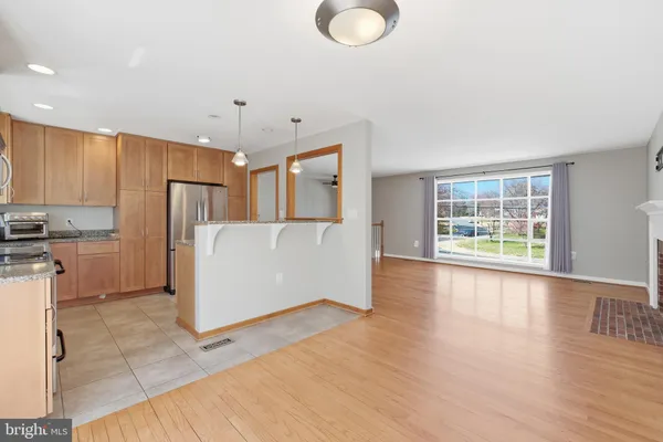 a view of a kitchen with wooden floor and electronic appliances