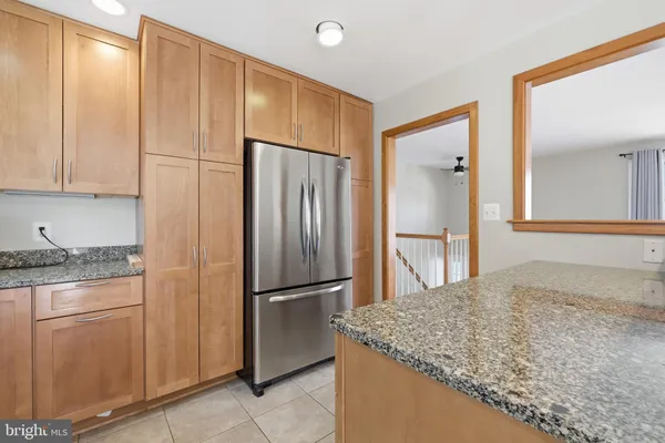 a kitchen with kitchen island granite countertop cabinets and refrigerator
