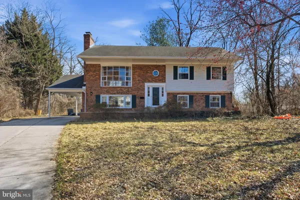 a front view of a house with a yard covered with snow