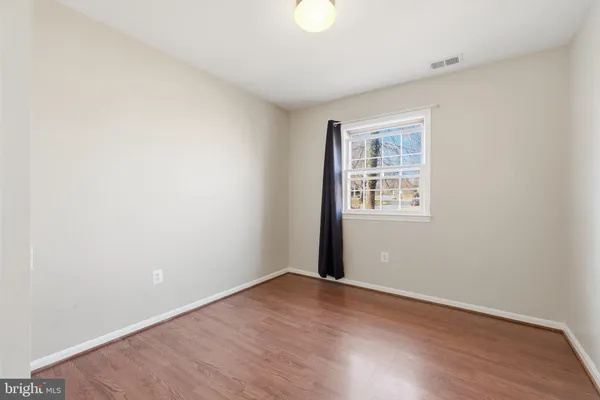 an empty room with wooden floor and closet