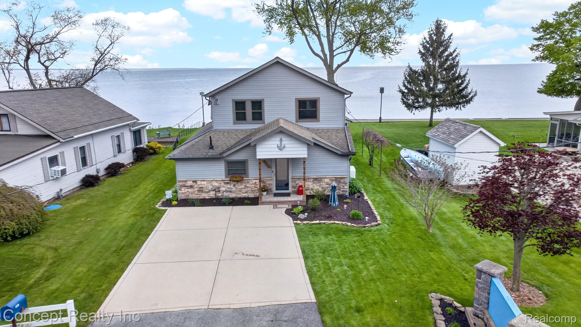 4720 Long Road Newport, MI 48166 - Photo 3 of 46 View of front facade featuring stone siding, a water view, and a front lawn