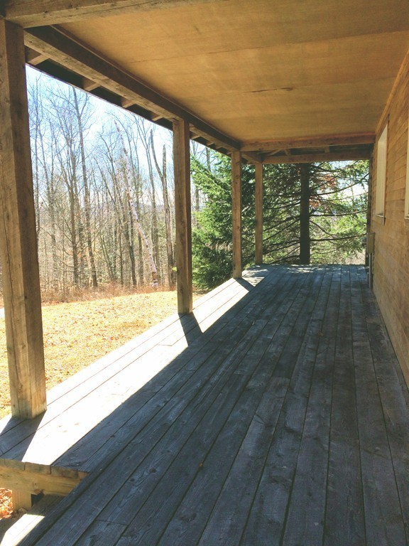 145 Leshure Road Rowe, MA 01367 - Photo 5 of 26 a view of an empty room with wooden floor and a window
