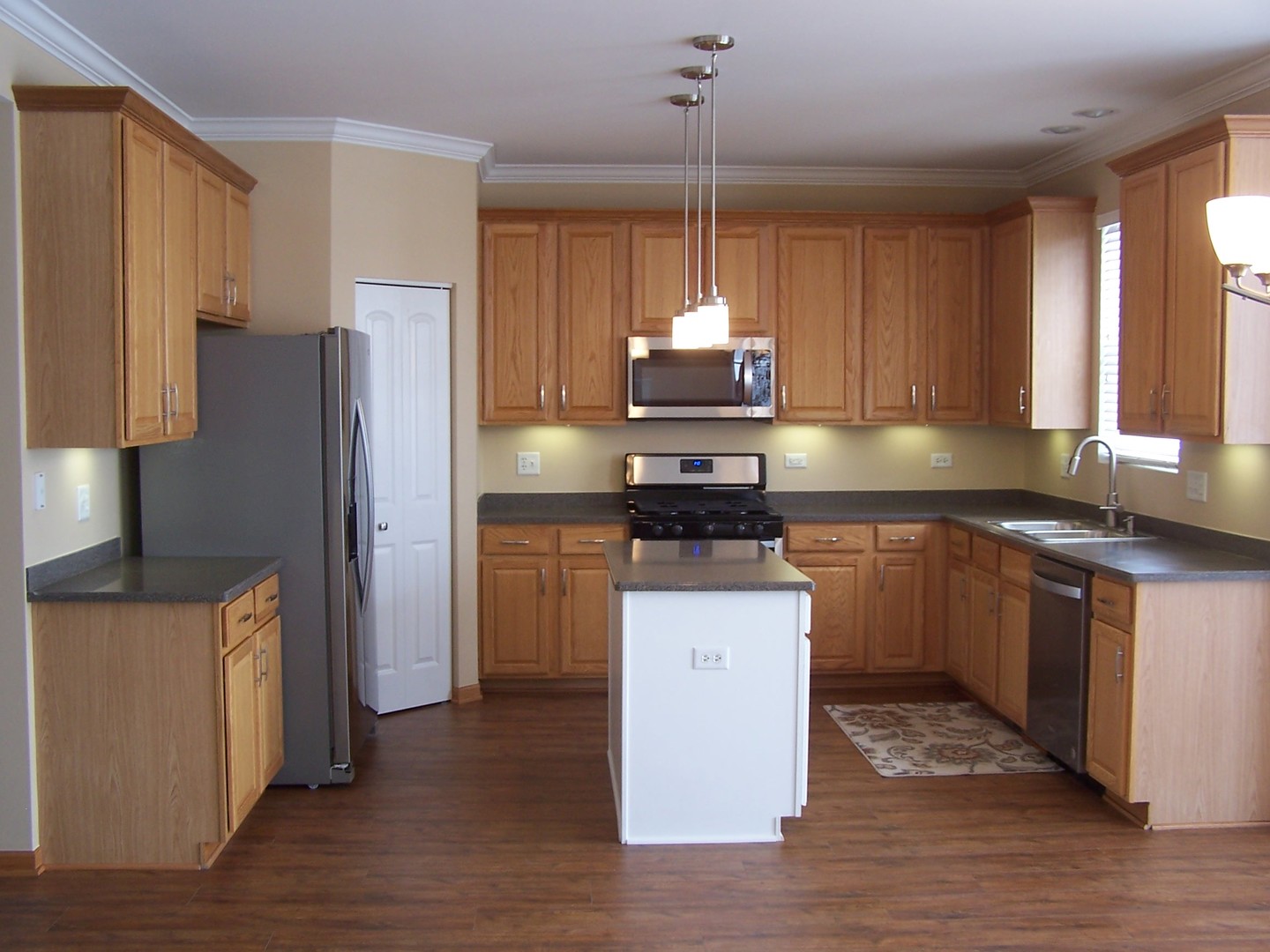 25216 Spring Street Manhattan, IL 60442 - Photo 3 of 21 a kitchen with stainless steel appliances a sink a stove a refrigerator and cabinets