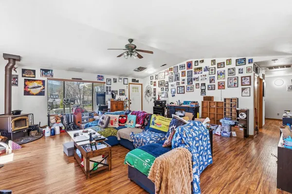 a living room with furniture kitchen view and a wooden floor