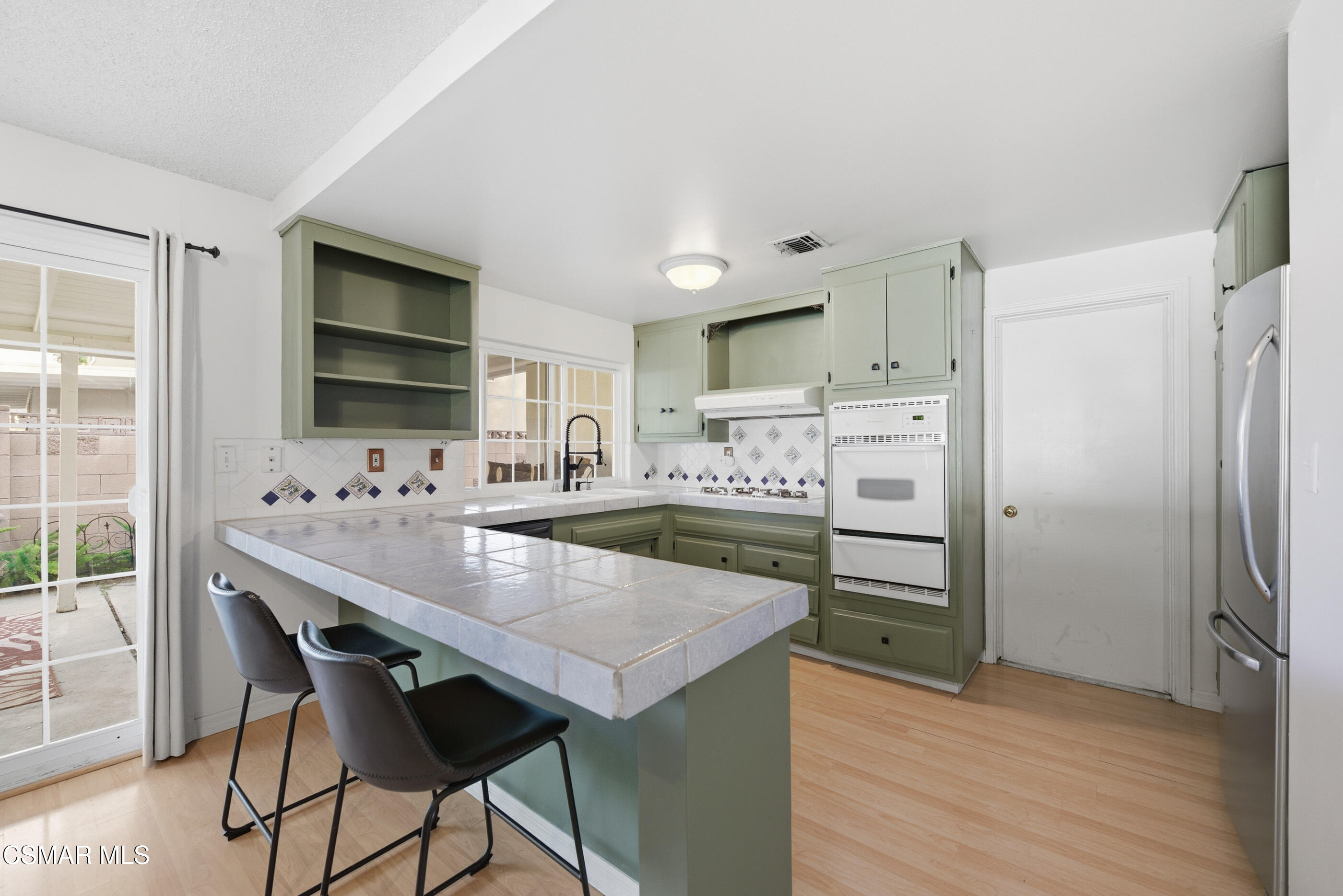 2267 Morley Street Simi Valley, CA 93065 - Photo 3 of 35 a kitchen with kitchen island a counter top space a sink appliances and cabinets