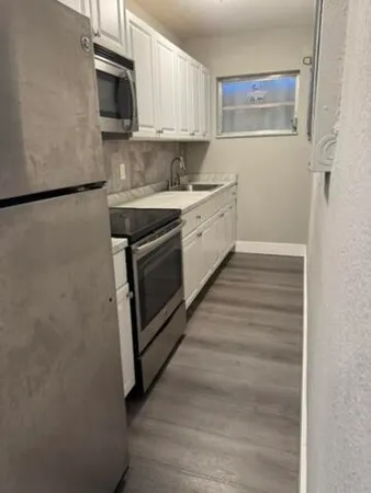 a kitchen with stainless steel appliances granite countertop a sink stove and microwave