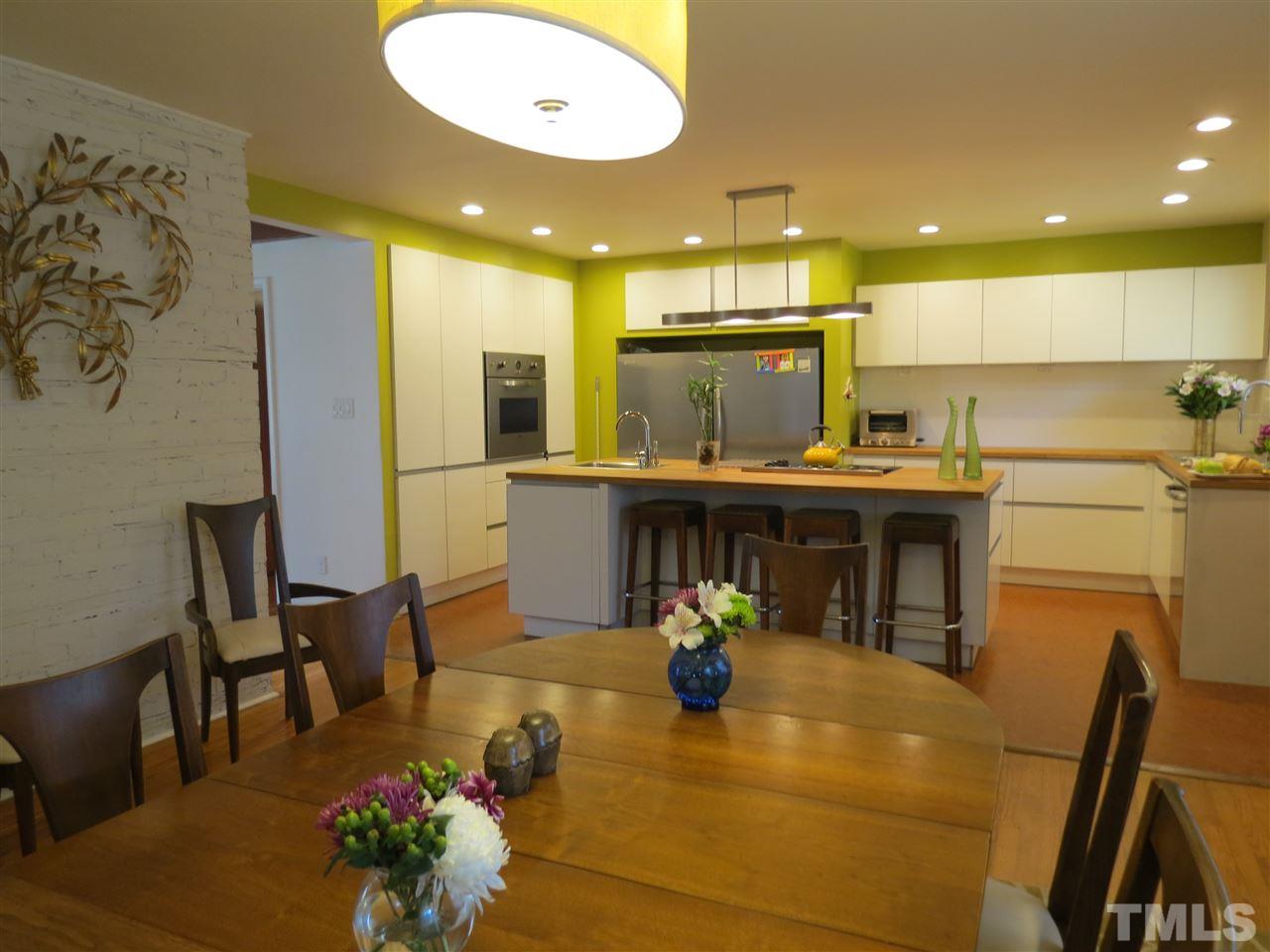 212 Bayleaf Drive Raleigh, NC 27615 - Photo 3 of 25 a view of a kitchen with kitchen island dining table and chairs
