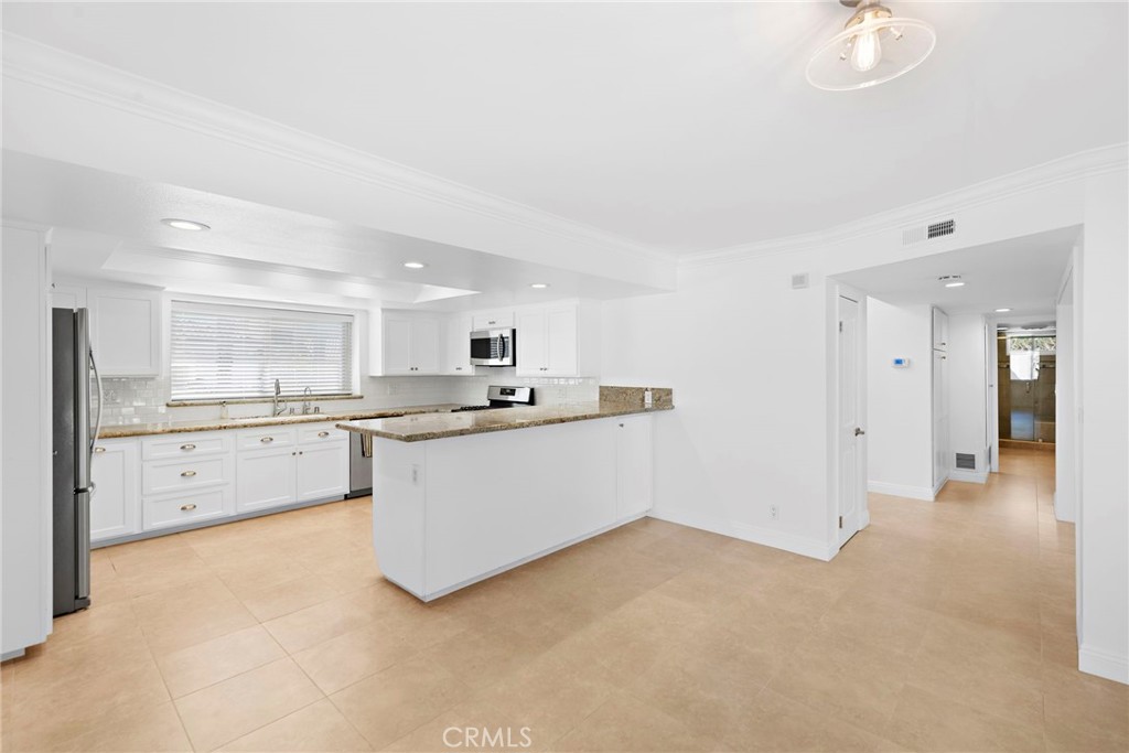 35491 Del Rey Dana Point, CA 92624 - Photo 11 of 48 a large white kitchen with cabinets and a refrigerator