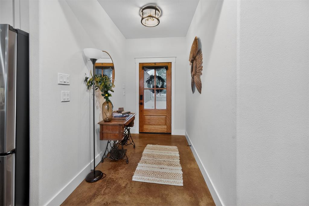 6371 Mill Run Road Athens, TX 75751 - Photo 4 of 40 Entryway featuring warm-toned flooring, a light wood door with glass panes, and a contemporary ceiling light fixture