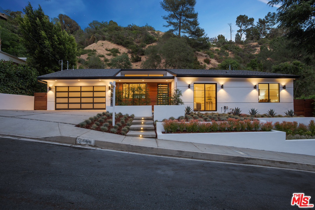 2084 Roscomare Road Los Angeles, CA 90077 - Photo 2 of 22 a front view of a house with a yard and garage